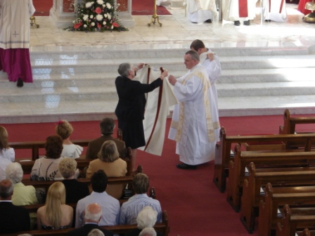 Don is vested with the dalmatic, presented by his wife Margaret.