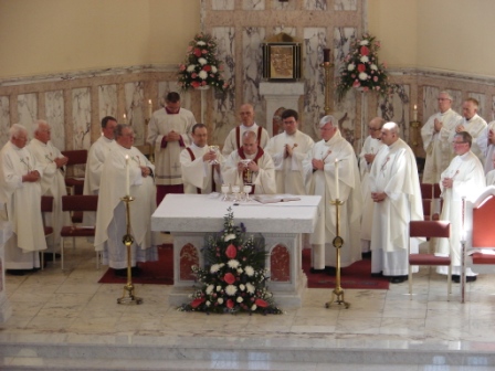 The Doxology. The new deacon raises the chalice.